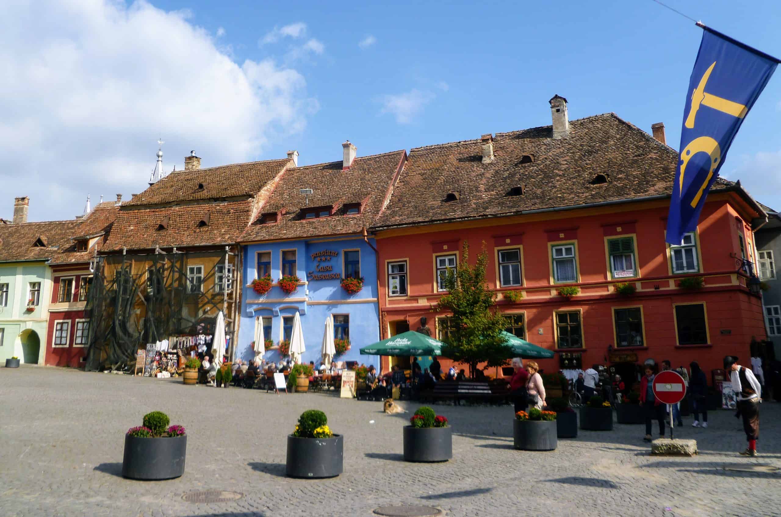 A image of Sighisoara's main square with cafes and shops