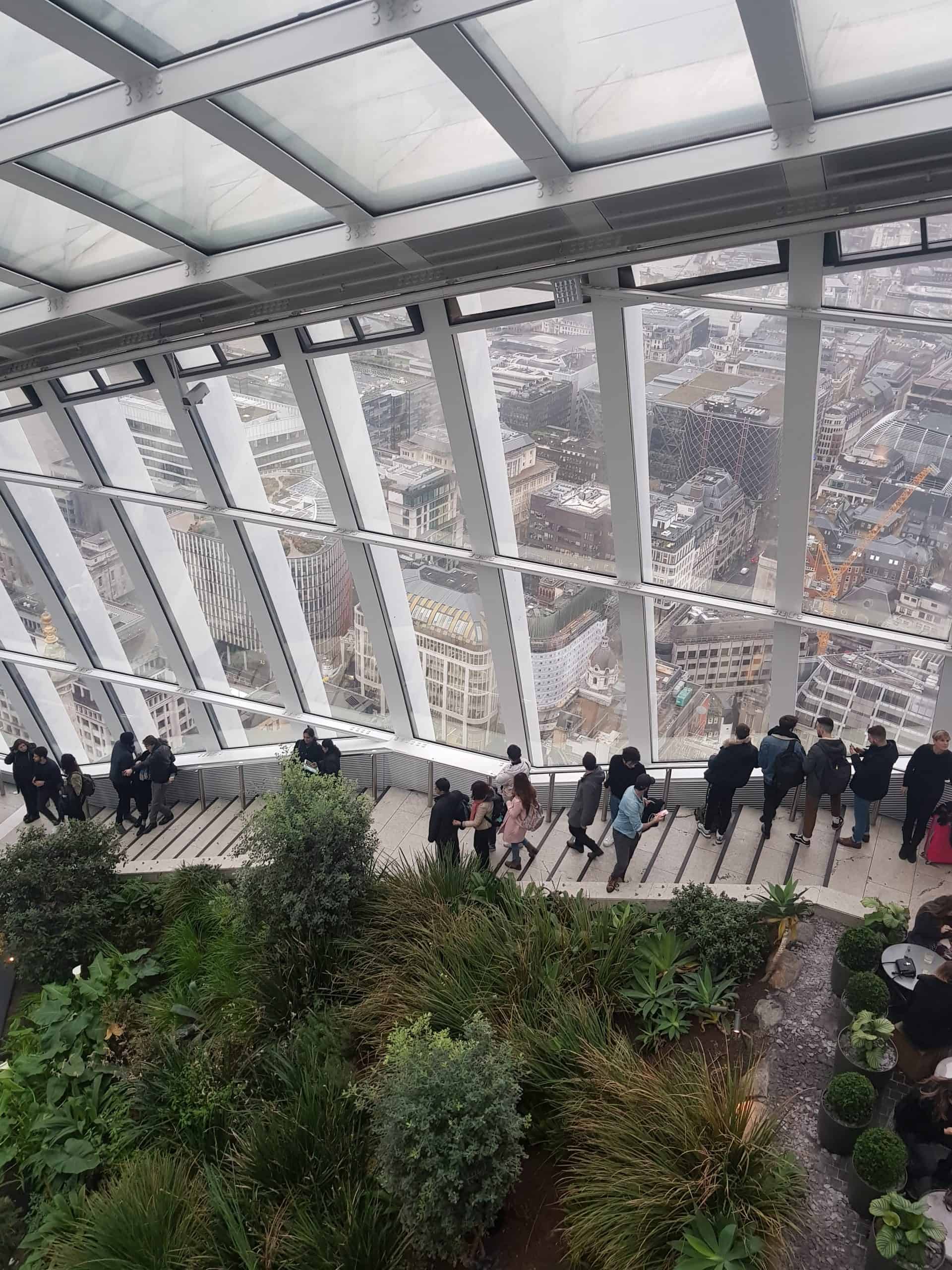 A photo from inside the skygarden, overlooking the gardens and out through the windows overlooking the city of London.