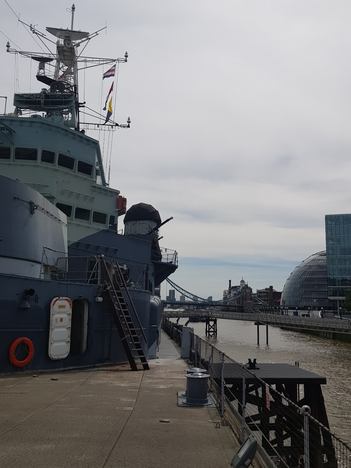 a front, side view of a WW2 battleship, on the river thames.
