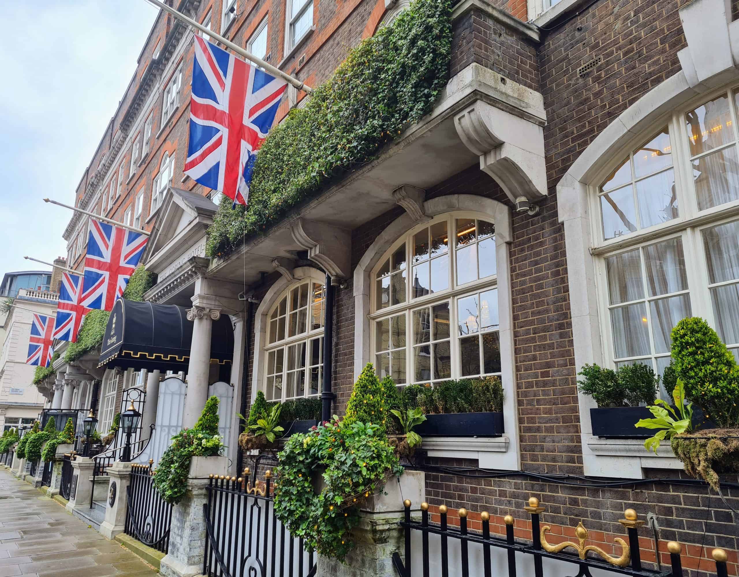 photo of a brown brick hotel with flower boxes and UK flags hanging from poles over the main entrance