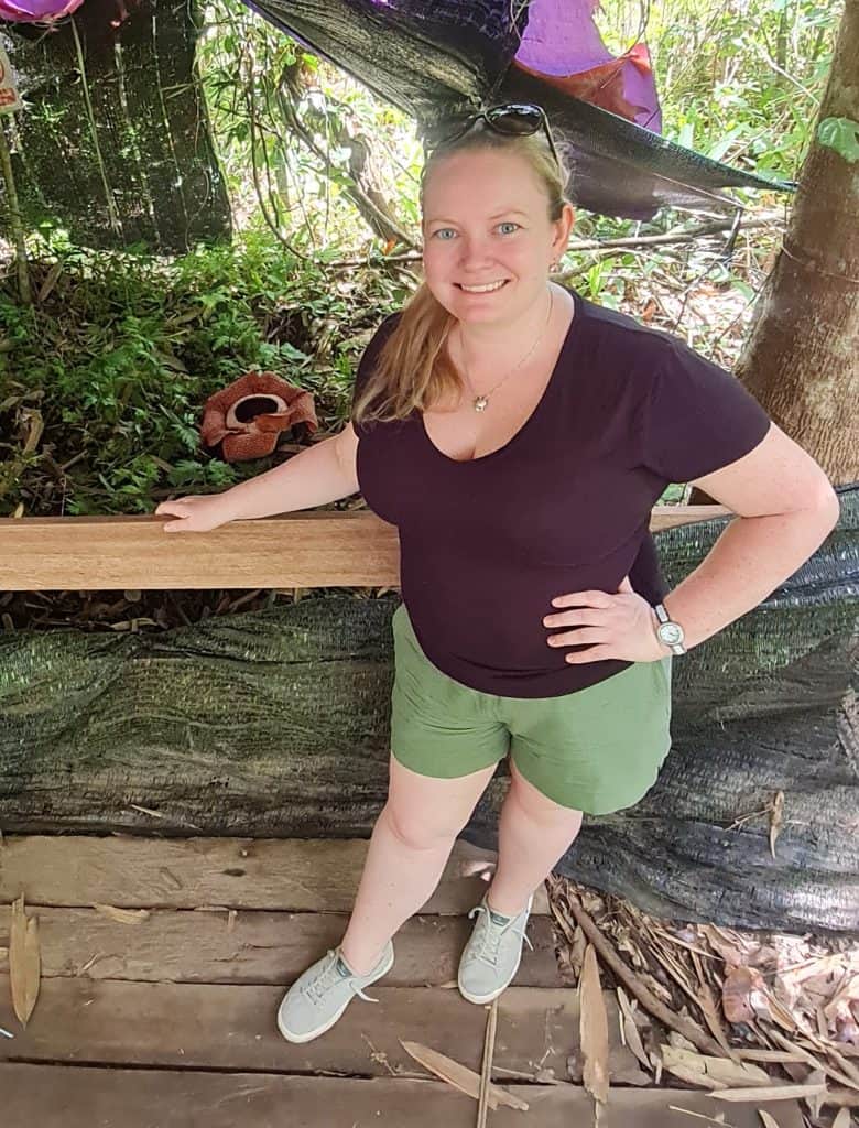 the blogger with a large reddish pink flower with 6 large petals on it growing on the ground. its is known as the Rafflesia flower.