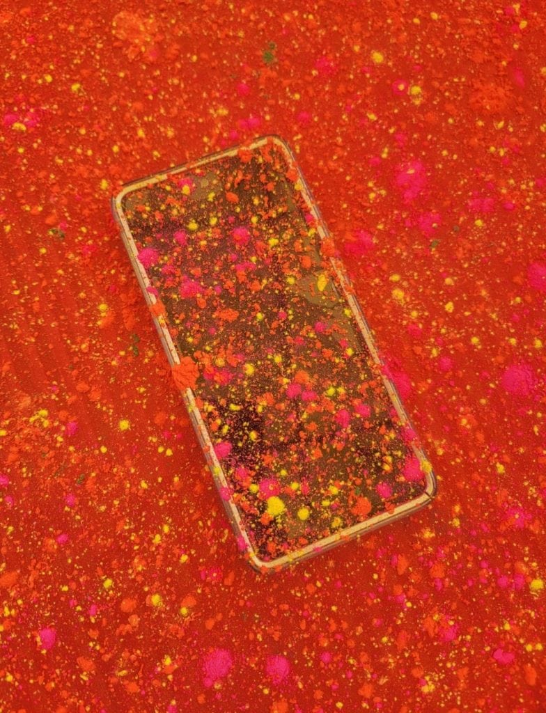 a phone splattered with pink, orange and yellow powder