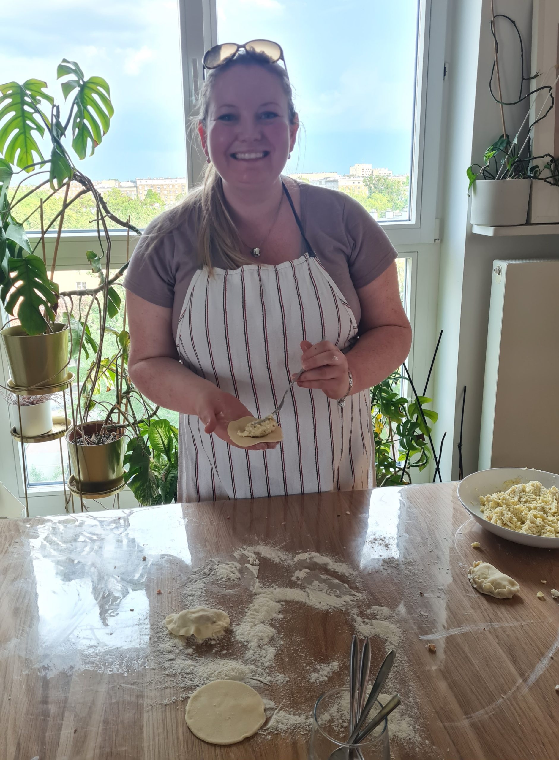 the author holding a pierogi that she is in the middle of making