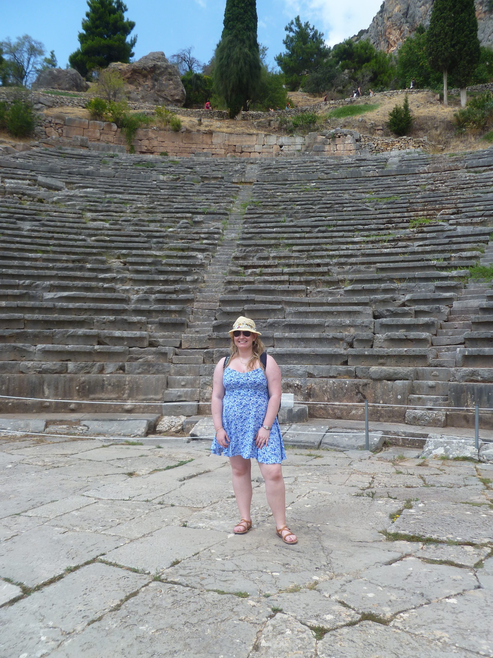 the blogger standing at the bottom of the Amphitheatre with all the seating behind her at Delphi