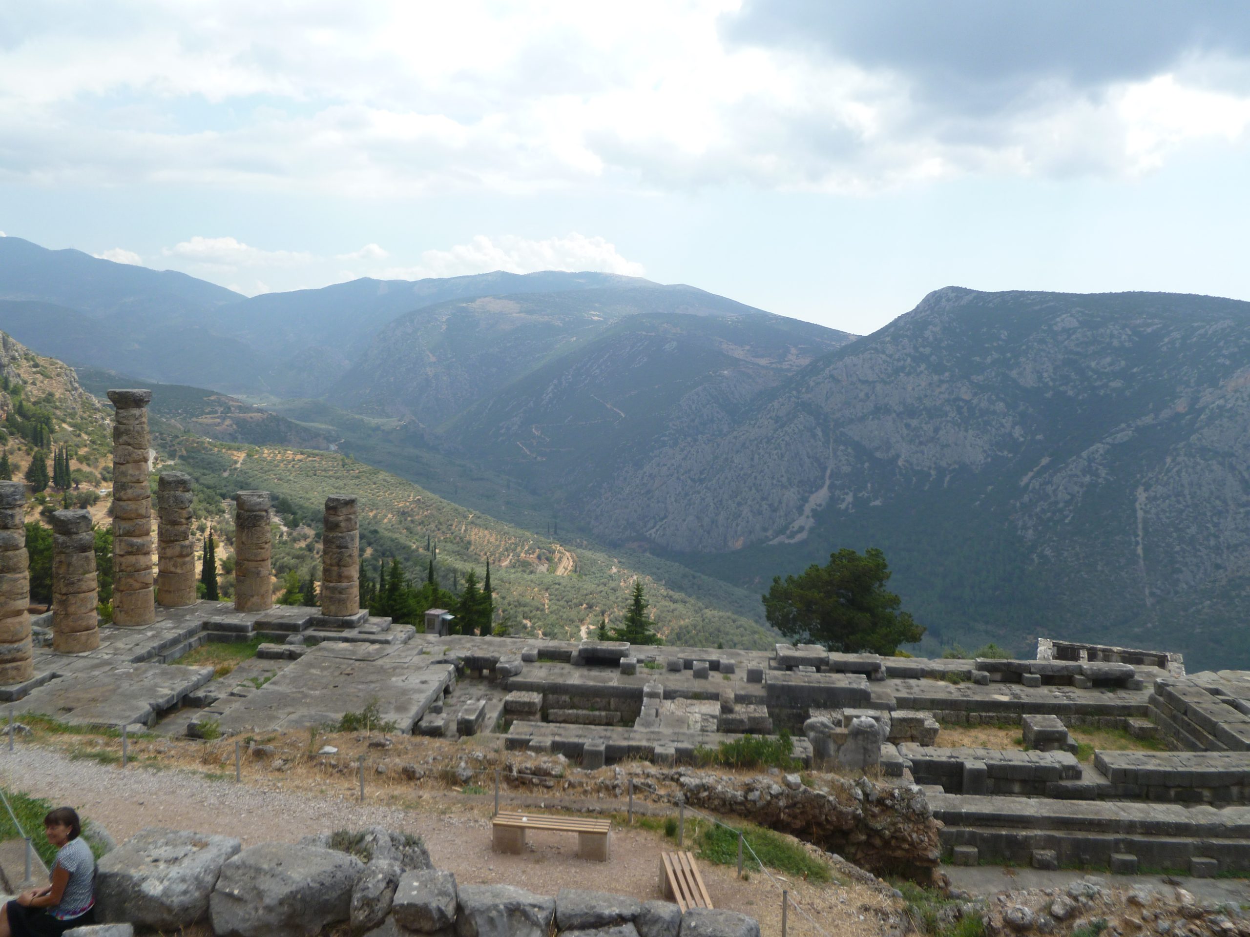 a scenic view of ruins surrounded by mountains at delphi